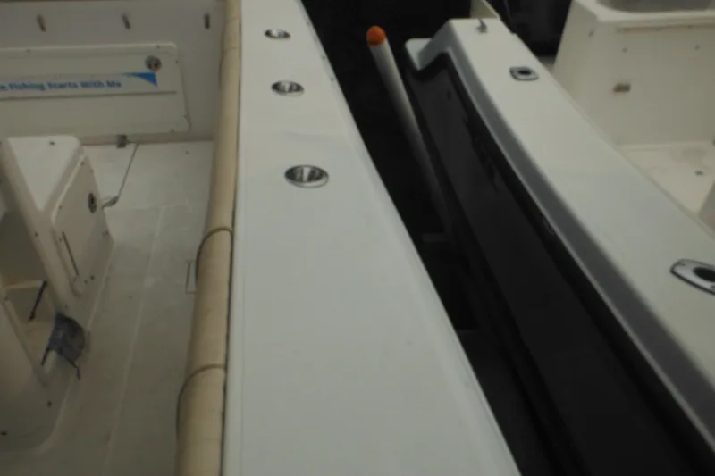 Slide: The Image of 2006 Southport 26 Center Console boat interior with rod holders and seating area. - 53