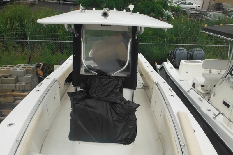 Slide: The Image of 2006 Southport 26 Center Console boat with covered seating, docked near other vessels. - 64