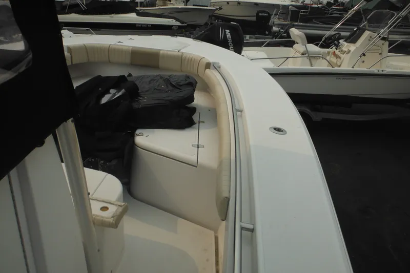 Slide: The Image of 2006 Southport 26 Center Console boat interior with seating and storage, docked among other boats. - 17