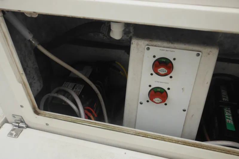 Slide: The Image of Battery compartment of a 2006 Southport 26 Center Console boat, showing switches and wiring. - 56