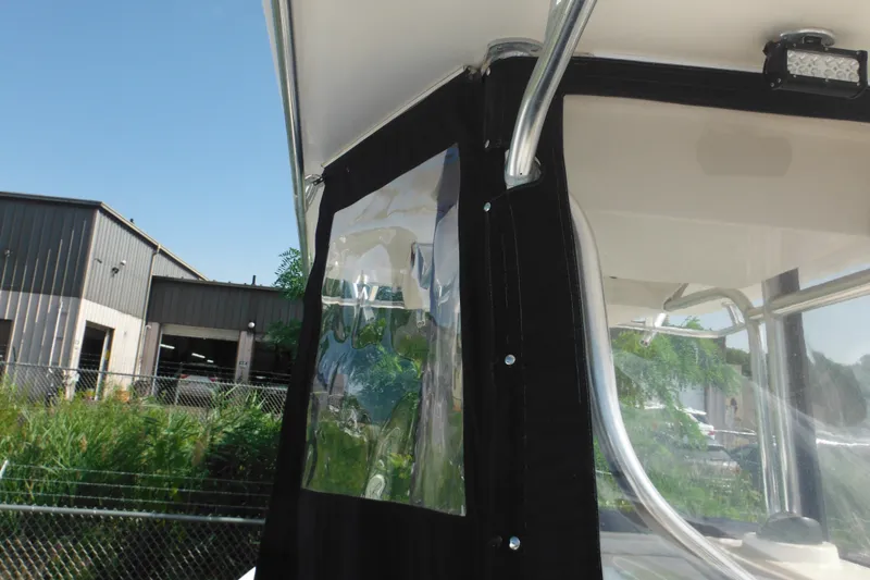 Slide: The Image of 2006 Southport 26 Center Console boat with clear enclosure and metal frame, outdoors. - 78