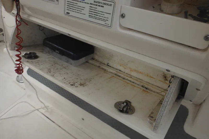 Slide: The Image of Storage compartment on a 2006 Southport 26 Center Console boat, showing wear and equipment. - 59