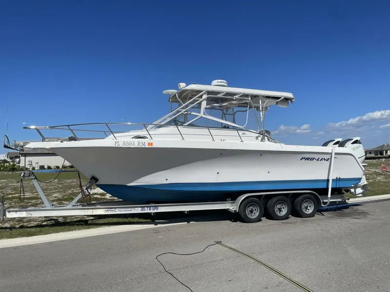 Slide: The Image of 2004 Pro-Line 30 Express Walkaround on a trailer, white and blue, with hardtop and twin engines. - 25