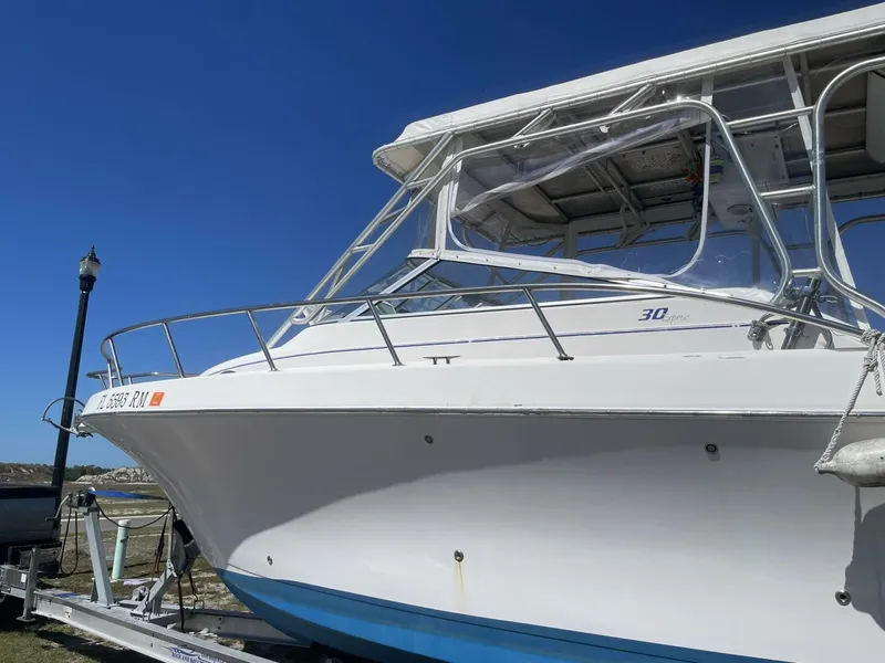 Slide: The Image of A 2004 Pro-Line 30 Express Walkaround on a trailer, featuring a blue hull and clear cover. - 19