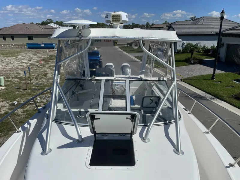 Slide: The Image of A 2004 Pro-Line 30 Express Walkaround with a spacious deck and clear windows, parked in a residential area. - 28