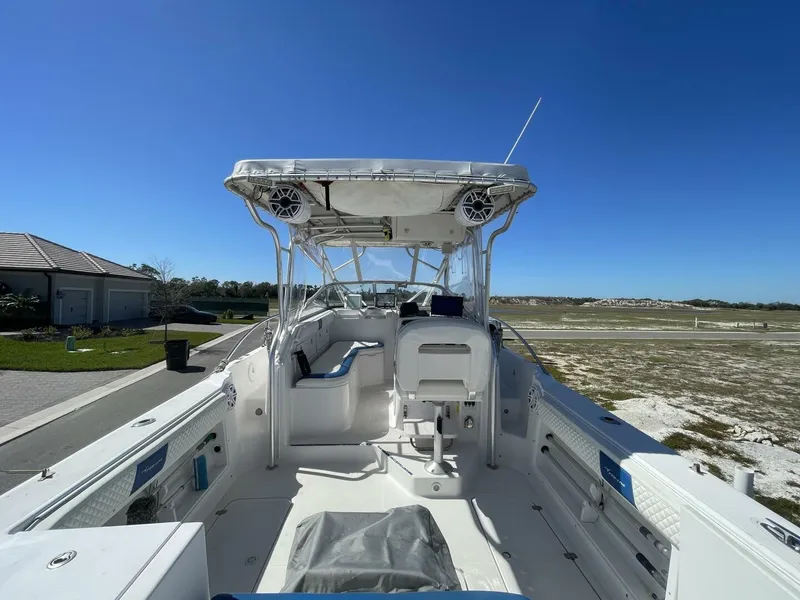 Slide: The Image of The image shows a 2004 Pro-Line 30 Express Walkaround boat. It features a spacious deck with seating and a covered helm. The sky is clear and blue. - 32