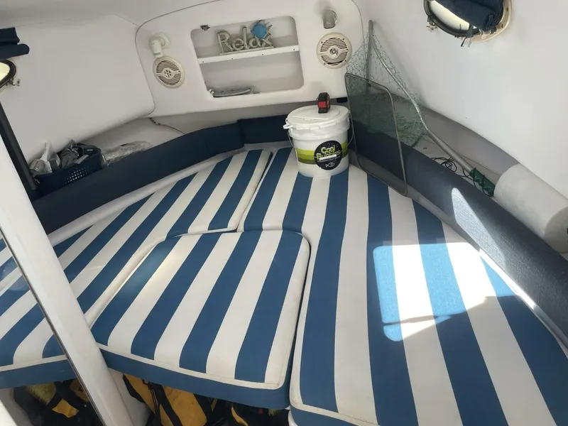 Slide: The Image of Interior of the 2004 Pro-Line 30 Express Walkaround with striped cushions and storage space. - 26