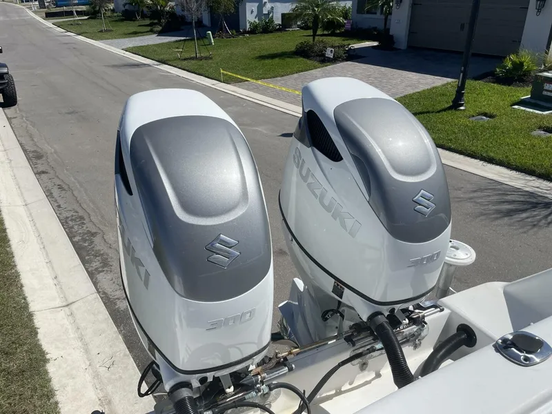 Slide: The Image of Two Suzuki outboard motors on a boat, parked in a residential area. - 15