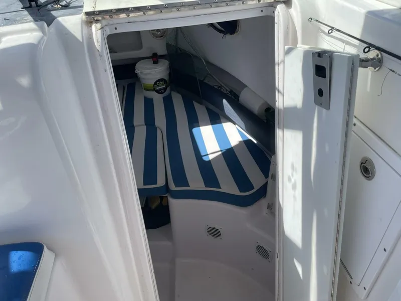 Slide: The Image of The image shows the interior of a 2004 Pro-Line 30 Express Walkaround with striped cushions. - 27