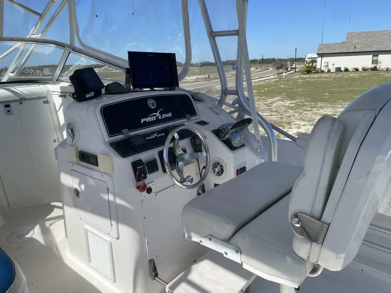 Slide: The Image of The image shows the helm of a 2004 Pro-Line 30 Express Walkaround boat. - 37