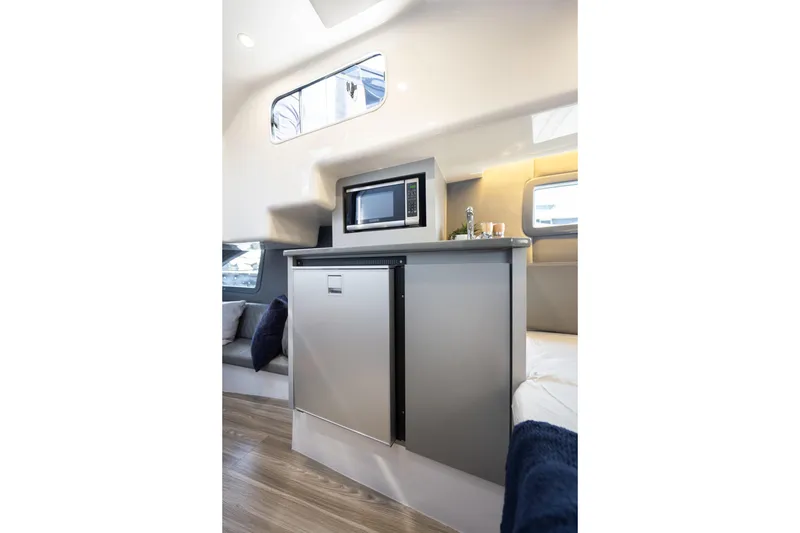 Slide: The Image of Modern interior of Hanover 347 yacht, featuring sleek kitchenette with microwave and compact fridge, 2026 model. - 35