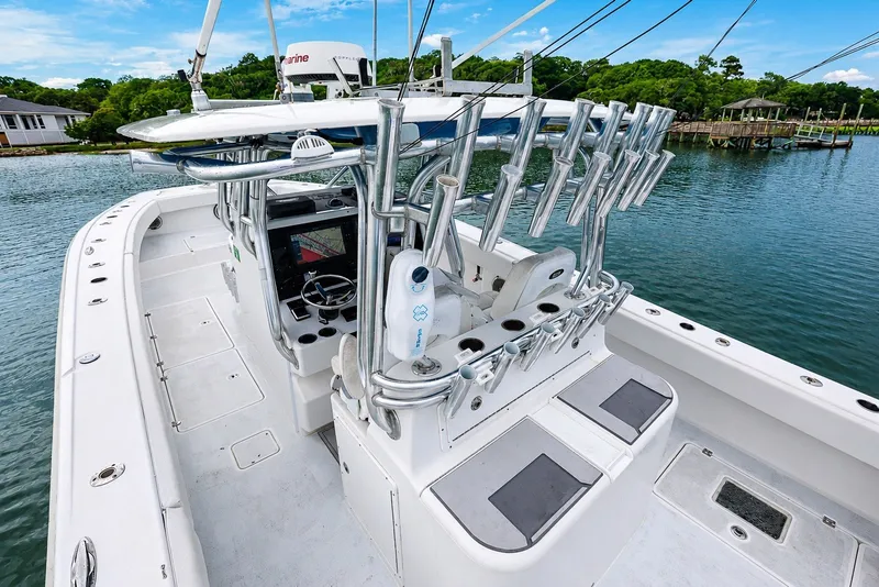 Slide: The Image of 2014 Freeman 37 boat with rod holders and navigation equipment on a calm waterway. - 14