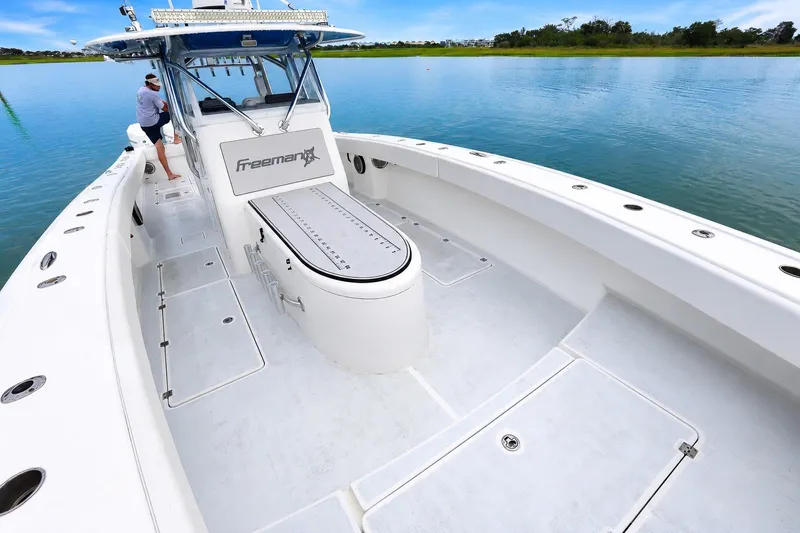 Slide: The Image of Freeman 37 boat on calm water, showcasing spacious deck and sleek design, 2014 model. - 10