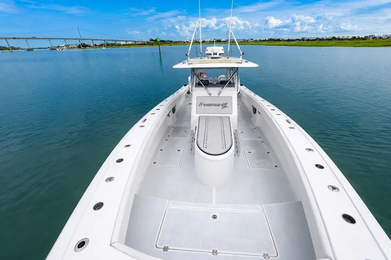 Slide: The Image of Freeman 37 boat on calm water, showcasing spacious deck and sleek design, 2014 model. - 8