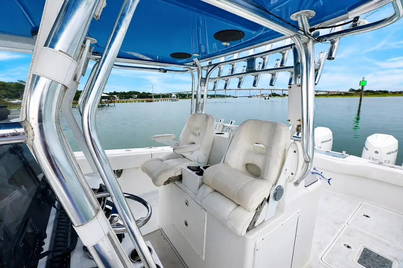 Slide: The Image of 2014 Freeman 37 boat interior with white seating and chrome details on a calm water backdrop. - 13