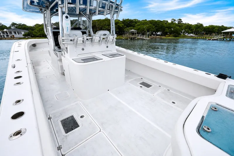Slide: The Image of 2014 Freeman 37 boat with spacious deck, docked on calm water, surrounded by greenery. - 9