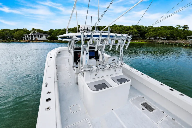 Slide: The Image of 2014 Freeman 37 boat on calm water, featuring spacious deck and fishing rod holders. - 12