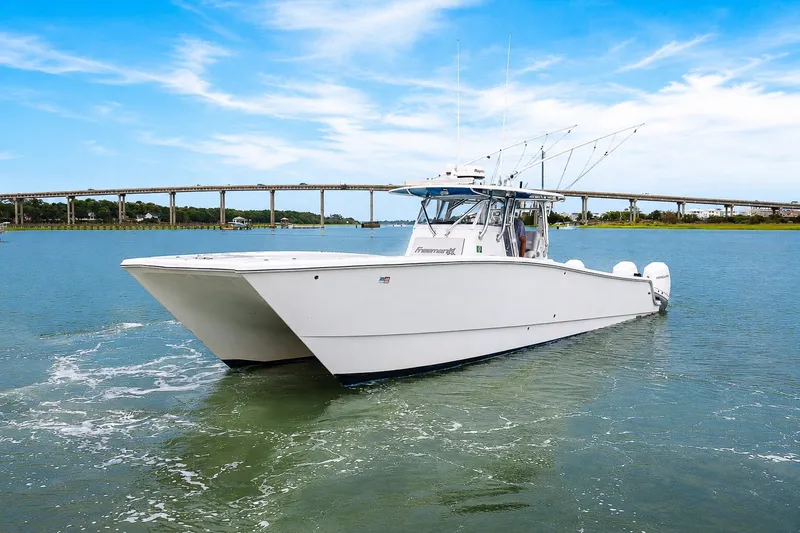Slide: The Image of 2014 Freeman 37 boat cruising on a calm river with a bridge in the background. - 5