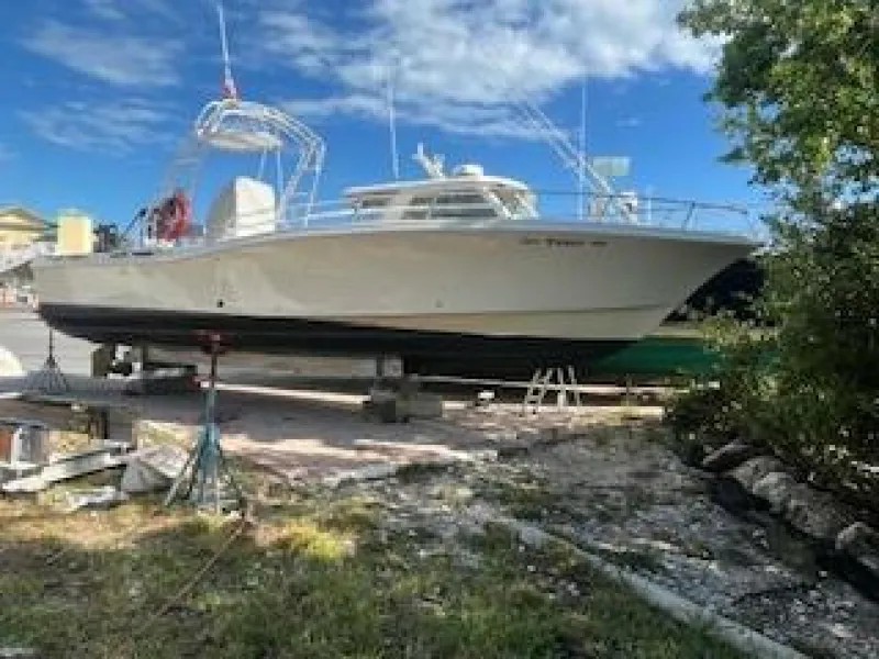 Slide: The Image of A 2019 OceanPro 35 boat is on land supported by stands, surrounded by trees and blue sky. - 12
