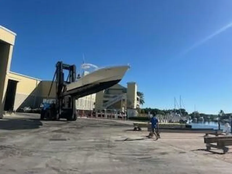 Slide: The Image of An OceanPro 35 boat is being lifted by a forklift from a warehouse. - 1