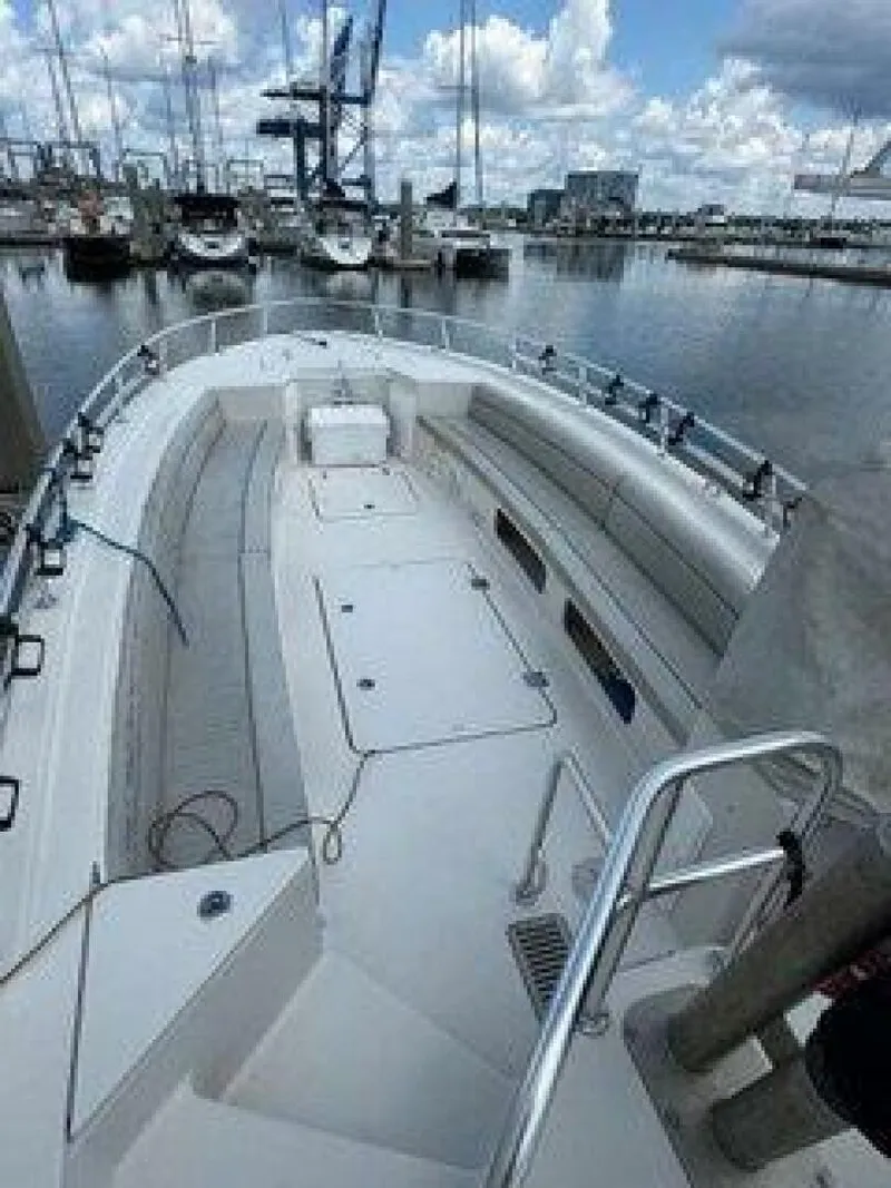 Slide: The Image of The image shows a 2019 OceanPro 35 boat at a marina, featuring a spacious deck and seating. - 3