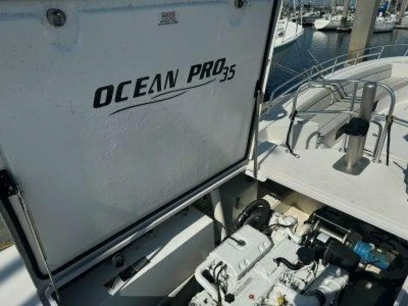 Slide: The Image of A 2019 OceanPro 35 with an open engine compartment showing the engine. Boats are visible in the harbor. - 10
