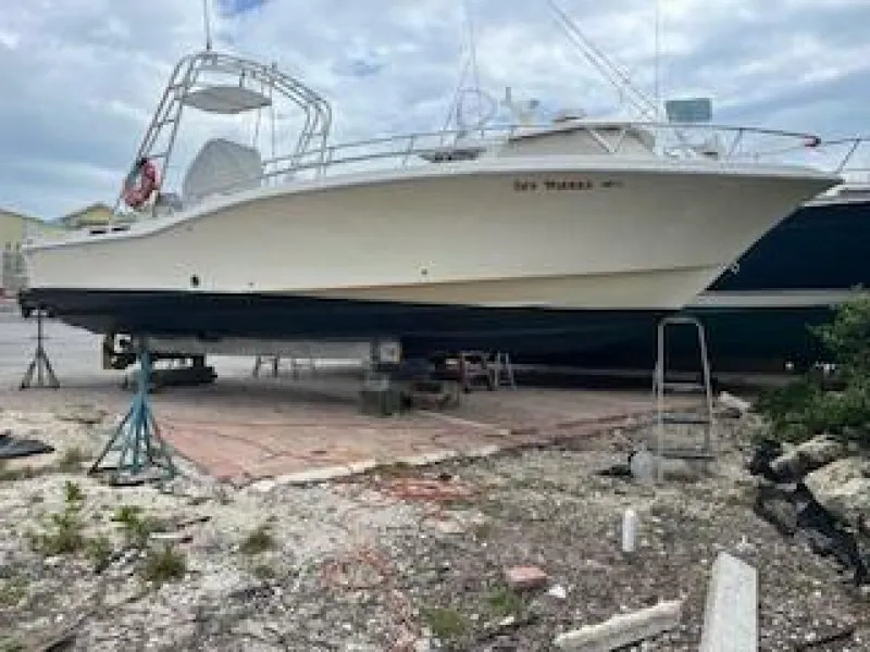 Slide: The Image of A white boat on a dry dock, supported by stands, with a cloudy sky above. - 13