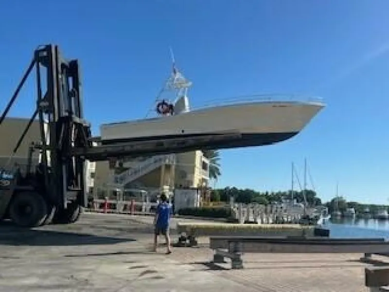 The Image of An OceanPro 35 boat from 2019 is being moved by a forklift at the harbor. - 0