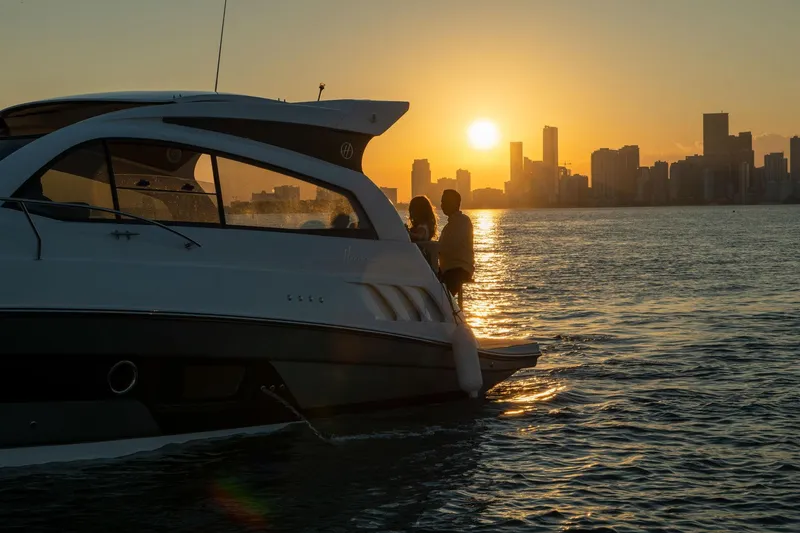 Slide: The Image of Luxury Hanover 375 yacht at sunset, 2026 model, with city skyline in background. - 69
