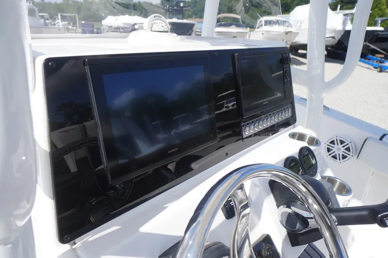 Slide: The Image of 2023 Tidewater 220 CC Adventure boat dashboard with dual Garmin displays and steering wheel. - 23