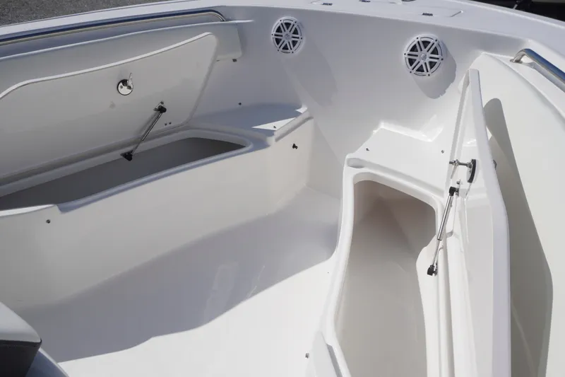 Slide: The Image of 2023 Tidewater 220 CC Adventure boat interior with open storage compartments and speakers. - 13