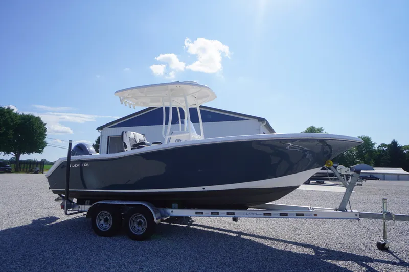 Slide: The Image of 2023 Tidewater 220 CC Adventure boat on trailer under clear blue sky. - 52