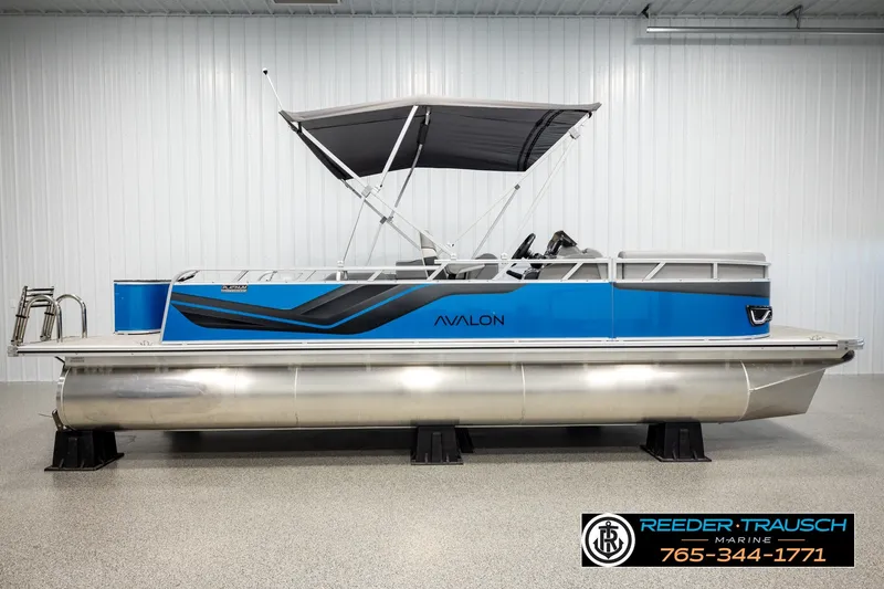 Slide: The Image of 2026 Avalon VEN85 RF pontoon boat with blue and gray design, displayed indoors. - 5