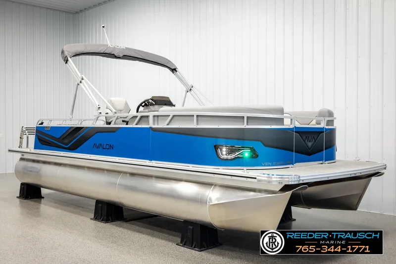 Slide: The Image of 2026 Avalon VEN85 RF pontoon boat in showroom, featuring sleek blue design and modern amenities. - 2