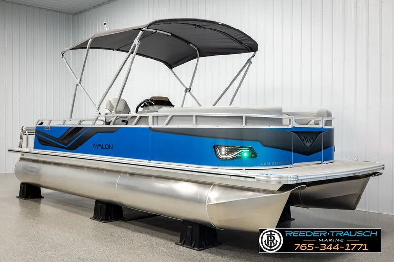 Slide: The Image of 2026 Avalon VEN85 RF pontoon boat with blue accents in showroom. - 3