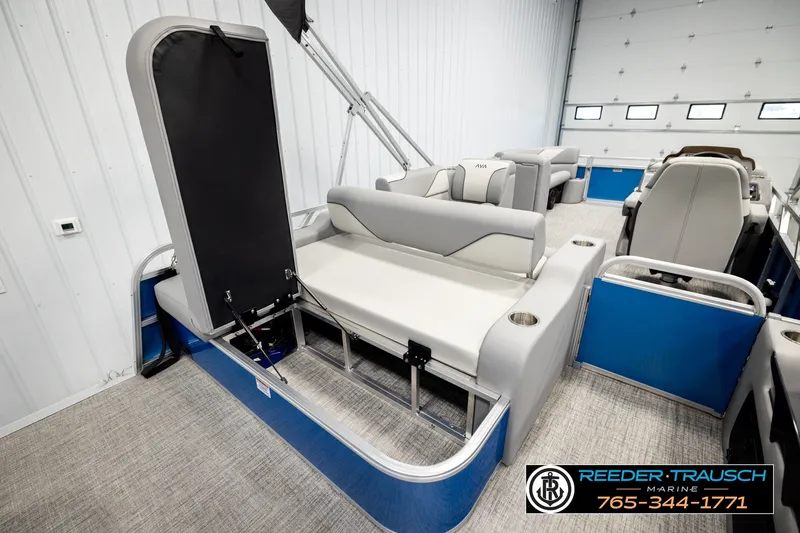 Slide: The Image of 2026 Avalon VEN85 RF pontoon boat interior with gray seating and blue accents in a showroom. - 29