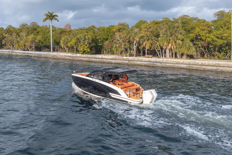 Slide: The Image of Luxury Hanover 387 boat cruising near lush shoreline, 2026 model. - 11