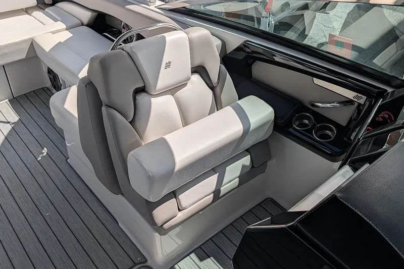 Slide: The Image of Captain's seat on 2019 Four Winns H290 OB boat, featuring luxurious design and cup holders. - 21