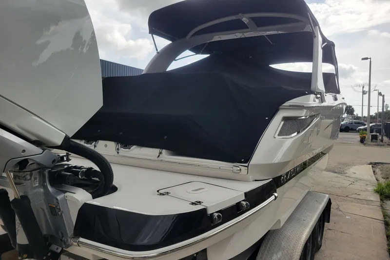 Slide: The Image of 2019 Four Winns H290 OB boat with black cover on trailer, rear view. - 34