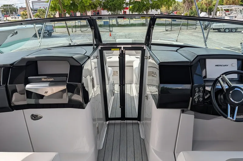 Slide: The Image of 2019 Four Winns H290 OB boat interior with steering wheel and dashboard view. - 25