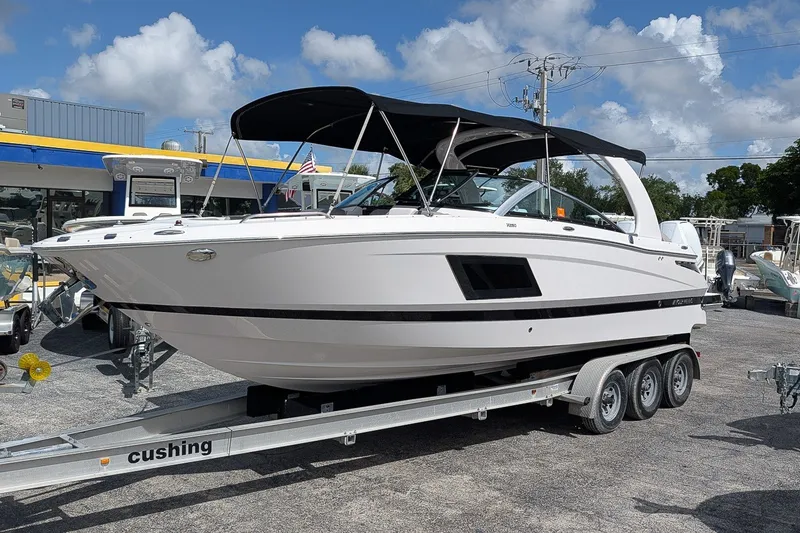 The Image of 2019 Four Winns H290 OB boat on trailer, featuring sleek design and black canopy. - 0