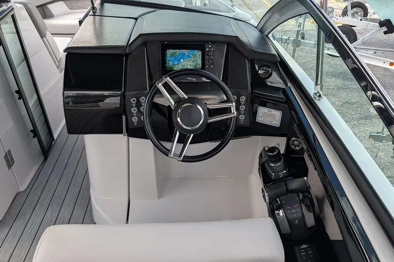Slide: The Image of 2019 Four Winns H290 OB boat helm with steering wheel and navigation display. - 16