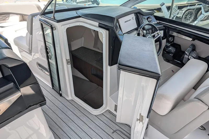 Slide: The Image of 2019 Four Winns H290 OB boat interior with helm, seating, and cabin entrance. - 19