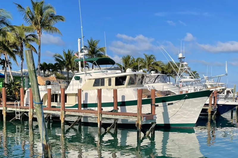 Slide: The Image of Kadey-Krogen 58 yacht docked at marina, 2001 model, surrounded by palm trees and clear blue sky. - 1
