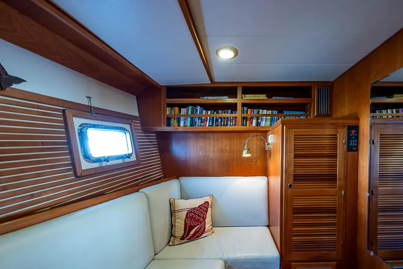 Slide: The Image of Cozy interior of 2001 Kadey-Krogen 58 yacht with bookshelves and cushioned seating. - 45