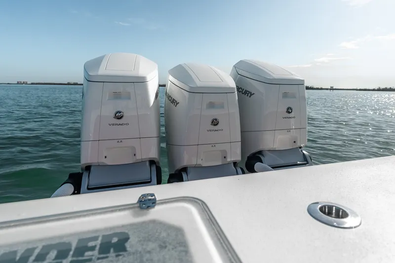 Slide: The Image of Triple Mercury Verado engines on a 2024 Contender 44 Fisharound boat in open water. - 26