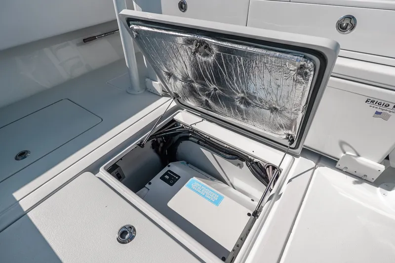 Slide: The Image of 2024 Contender 44 Fisharound boat storage compartment with open hatch and visible wiring. - 24