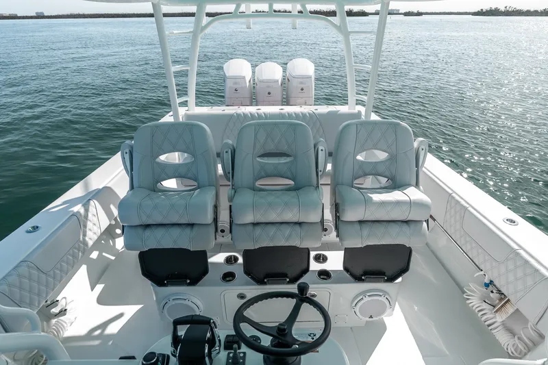Slide: The Image of 2024 Contender 44 Fisharound boat interior with three cushioned seats and steering wheel. - 37
