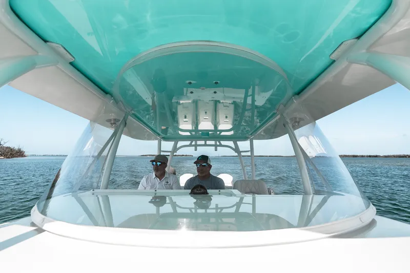 Slide: The Image of 2024 Contender 44 Fisharound boat cruising with two people under a turquoise canopy. - 51