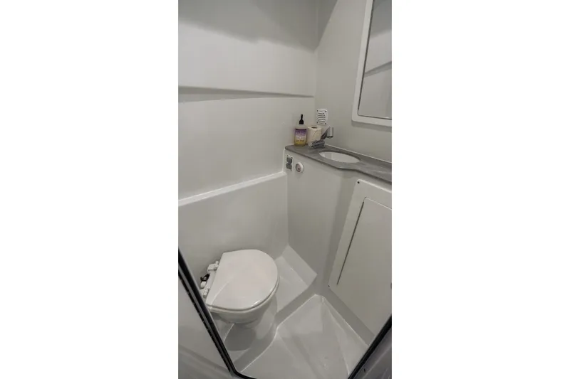 Slide: The Image of 2024 Contender 44 Fisharound boat bathroom with compact toilet and sink. - 67